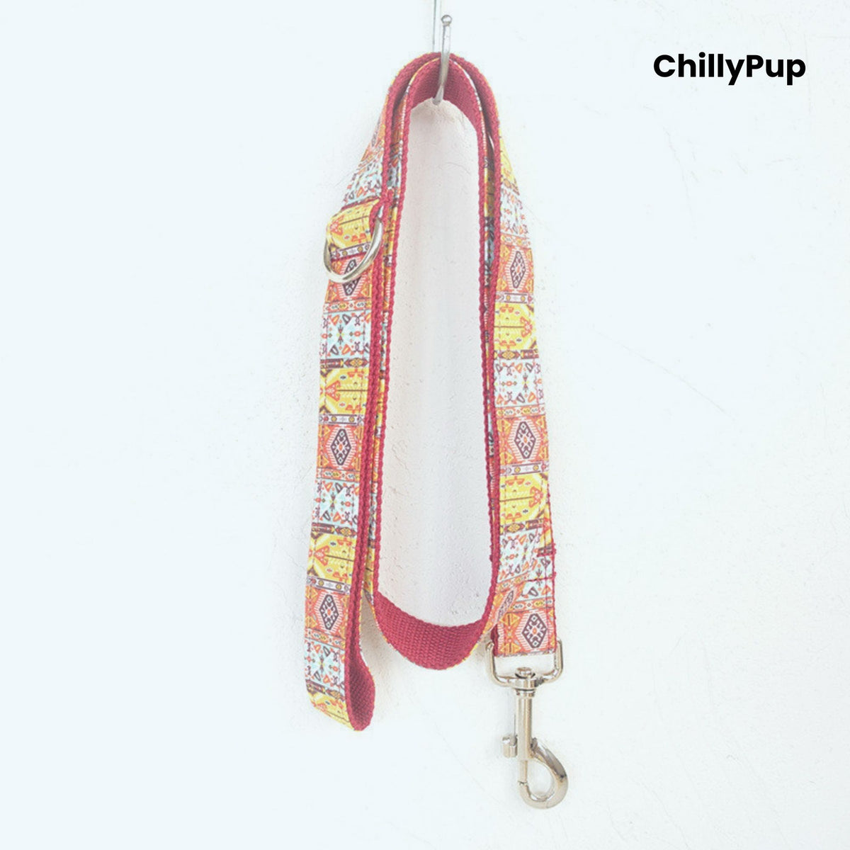 Dog collar with colourful pattern and metallic clasp on a white background, branded 'ChillyPup'.