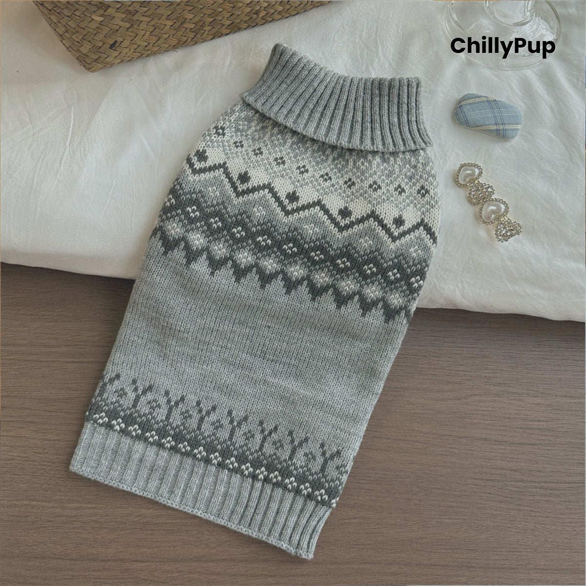 Gray knitted dog sweater with a pattern on a wooden surface, branded 'ChillyPup'.